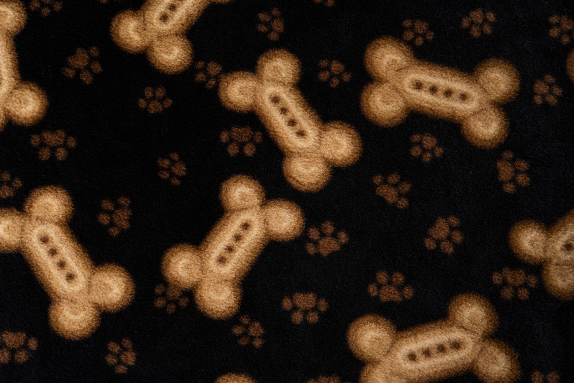 Brown dog bones and paw prints on black polar fleece fabric.